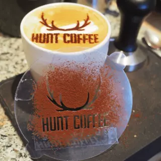 Using a food stencil, a deer antler with a wordmark was applied to a cappuccino.