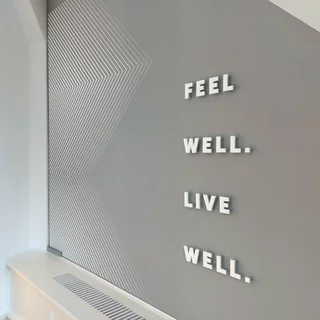 Komplexes Motiv mit einer Malerschablone an die Wand gebracht und ein Acrylglas Schriftzug mit Abstandshaltern