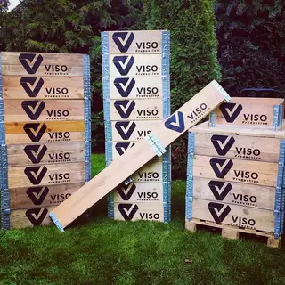 Labeling stacked wooden crates outdoors with company logo