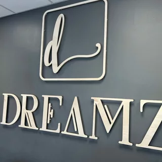 Ein Holzlogo ist an der Wand montiert mit dem Wort DREAMZ
