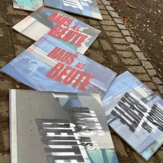 Mehrere fertiggestellte Plakate liegen auf dem Boden