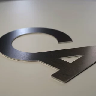 Zuschnitt aus geschliffenen Edelstahl als hochwertiges Firmenlogo