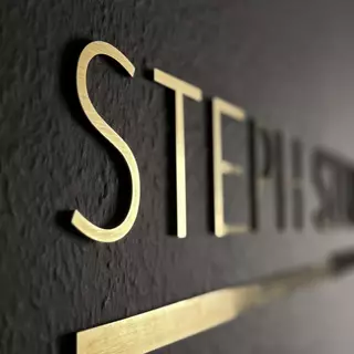 Seitlich fotografierte Detailansicht eines Schriftzugs, die den 3D-Effekt und die selbstklebende Befestigung betont.