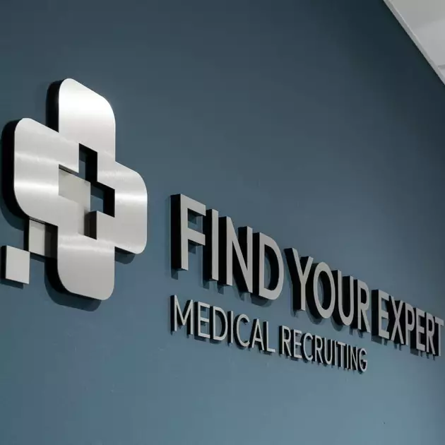 3D lettering and a logo mounted on a blue wall.