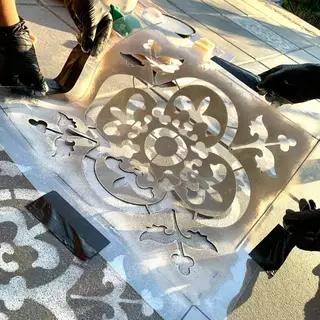 A template is lifted after spraying a floor tile
