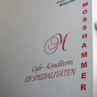 Wandbeschriftung einer Konditorei mit einer Malerschablone für individuelle Schriftzüge