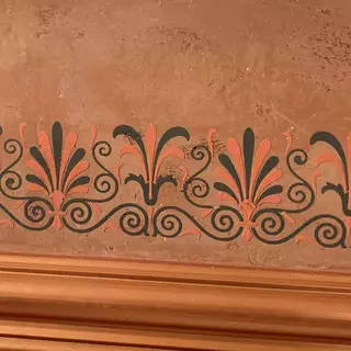 Verputzte Ornamente an einer Wand in zwei Farben