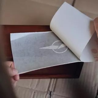 A protective film is peeled off from the painter stencil with a wing design.