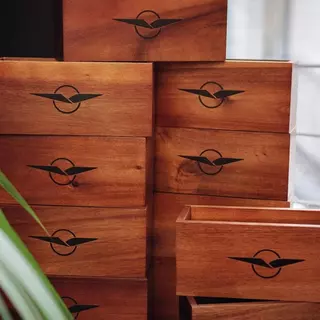 Multiple wooden boxes with a winged logo are stacked on top of each other - Order painter stencils online.