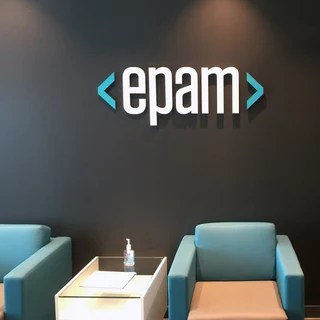  epam logo made of acrylic glass on a dark wall with 2 armchairs