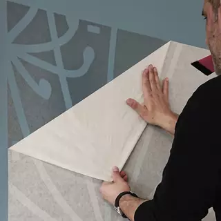 The transfer film of a large wall stencil is peeled off