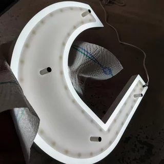 Shown is the backside of a backlit LED logo designed for mounting with spacers.