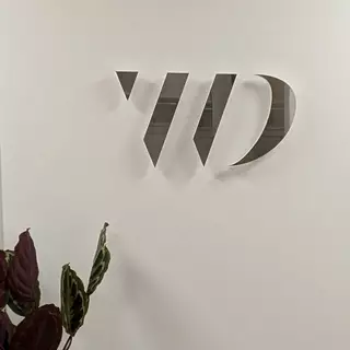 Logo aus silber poliertem Edelstahl auf Acrylglas, selbstklebend montiert.