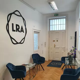 Matt schwarzes Plexiglas Logo LRA hängt in einem Eingangsbereich